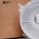 Bambu Lab brown retail box with vacuum-sealed PLA Marble spool beside it