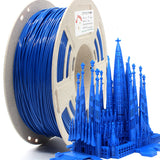 1kg spool of RepRapper Tech PLA blue with speckled flange and label next to a detailed matching blue 3D-printed Sagrada Família model on white background