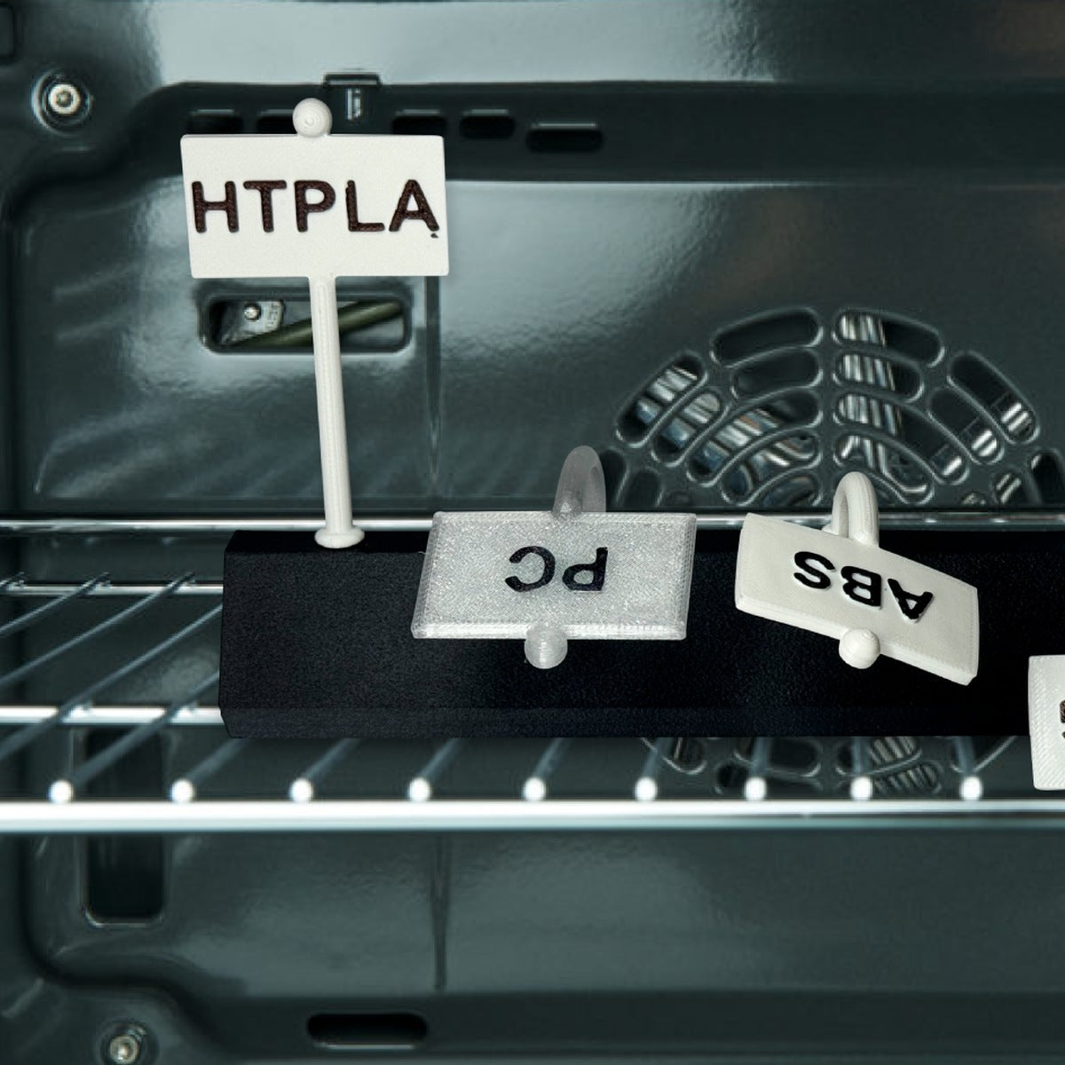 Oven rack heat test: HTPLA sign stays upright while PC, ABS, PETG signs sag