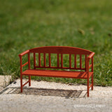 Red Granite miniature park bench on outdoor stone with grass bokeh