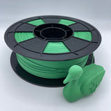 Green 3D printer filament wound on a black spool, shown against a plain light gray background.