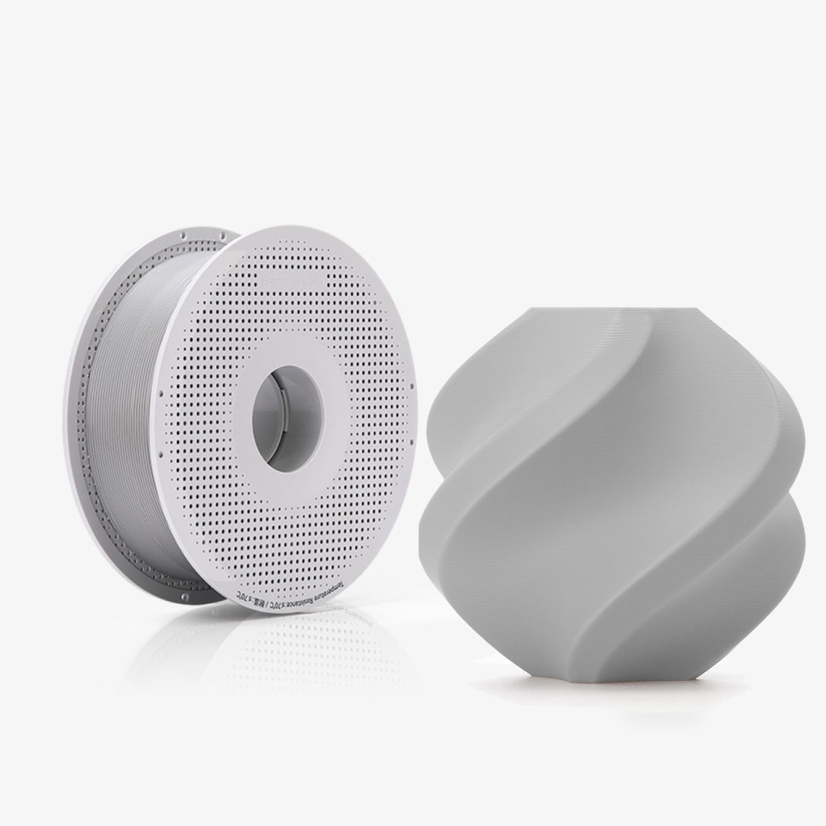 Bambu PLA Tough+ spool next to a grey printed vase