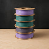 RepRap Warehouse Recycled PLA filament, stack of five spools in lavender, teal and grey-purple on cardboard spools